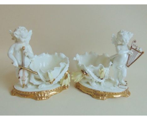 Pair of Moore Brothers scalloped edge dishes, with cacti leaves and lotus leaves supporting two cherub musicians, one playing