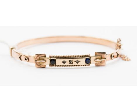 A sapphire and diamond bangle mounted in rose metal probably 9ct gold, in the style of a buckle, complete with safety chain, 