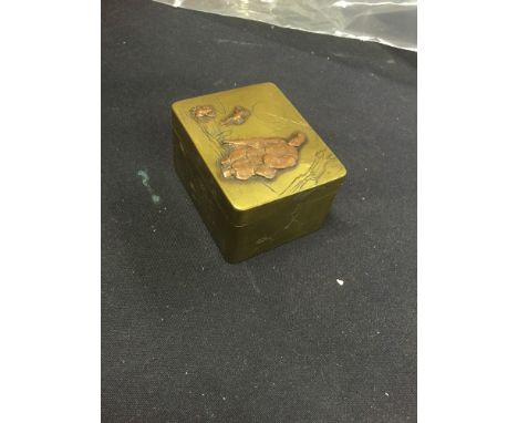 A Japanese Meiji period copper and brass rectangular snuff box, the cover decorated with figure and frogs in high relief, the