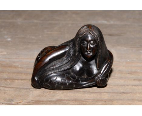 A Japanese dark wood carved Netsuke, depicting a Mermaid, signed to the base 