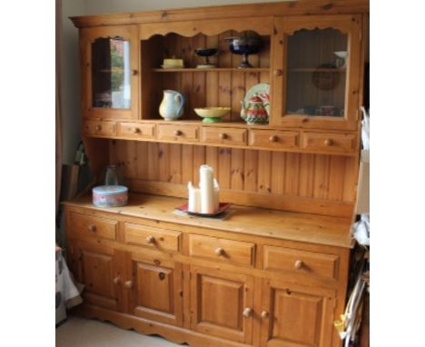 A contemporary traditionally made pine dresser and rack, the upper section with two doors and six spice drawers, the base sec