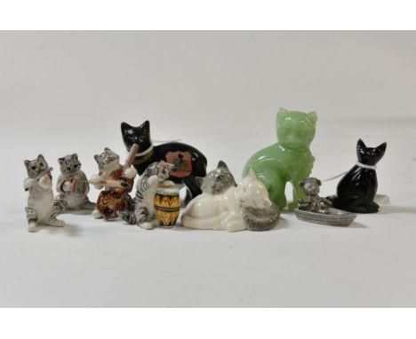 A 1920's Manx cat, four orchestral 'Cats playing Instruments', a carved 'gold stone' cat, a jade/resin cat and a Royal Doulto