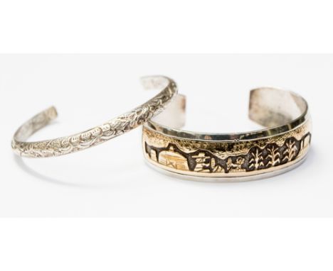 A silver and gold inlaid torque bangle depicting a scene, approx width 18mm, and a diameter size of approx 60mm, along with a
