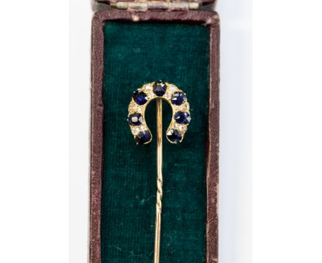 A horseshoe shaped diamond and sapphire stick pin, rose and yellow metal set