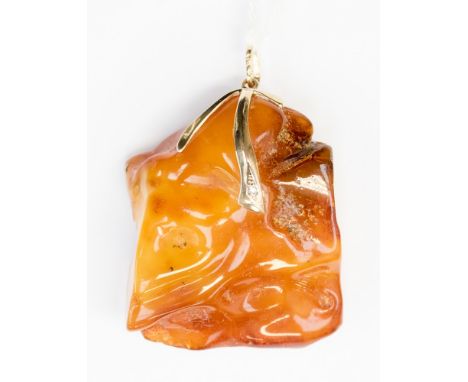 A large piece of butterscotch coloured amber, polished, unfacetted and cut pendant shape, rectangular dimensions approx 5.5cm
