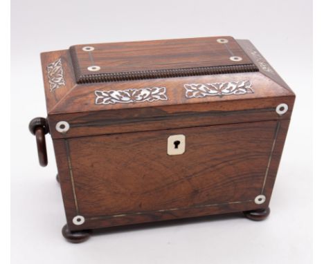 An early 19th Century rosewood inlaid mother-of-pearl tea caddy, sarcophagus shaped with ring handles on four stud supports, 