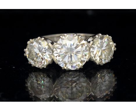 A three stone old diamond and platinum ring, comprising round brilliant cut diamonds, the principal diamond weighing approx 1