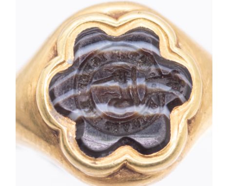 An early 19th century hardstone gold seal signet ring, comprising a six petaled flower motif of banded agate, bezel set, the 