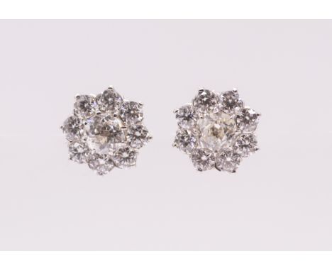 A pair of diamond and 18ct white gold flower cluster studs, each earring comprising an old European cut diamond set to the ce