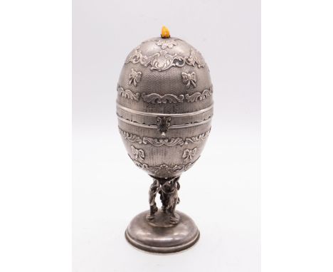A Continental white metal (untested) egg shaped engine turned music box, the cover and body with engine turned geometric desi