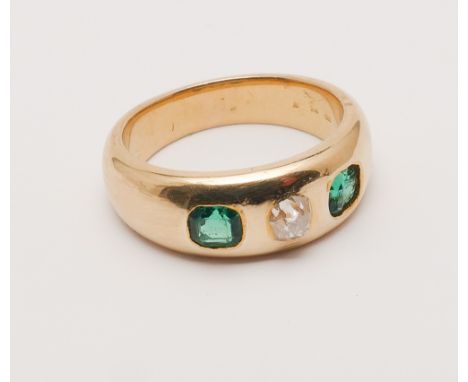 18ct yellow gold half hoop ring set with two emeralds and a diamond to the centre, ring size K