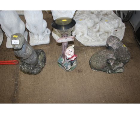 A concrete ornament in the form of an otter; a solar light decorated with a gnome and a concrete ornament in the form of hedg
