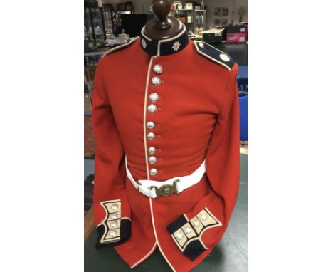 A vintage Coldstream Guard tunic and Kings Crown belt. Red wool body, with dark blue facings and anodised buttons. Embroidere