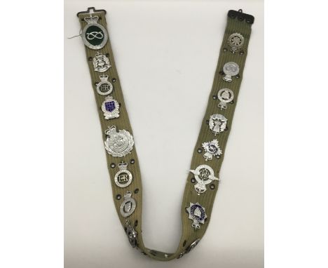 A webbing belt, fitted with numerous vintage chromed, enamelled, examples of police constabulary badges and others. To includ