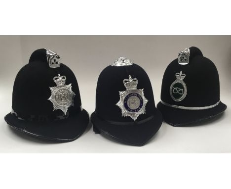 3 vintage British Police helmets, each with chromed badges applied to the fronts. To include: a Queen Elizabeth II Metropolit