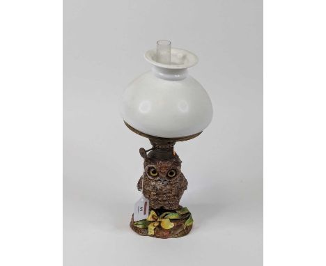 A late 19th century novelty oil lamp, having an opaline glass shade over brass burner and pottery base in the form of an owl,