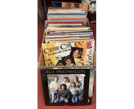 A collection of vintage 12" vinyl records, to include the Eagles One of These Nights, Culture Clu b Ultimate Dance Mix, Bryan