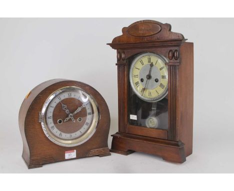 An early 20th century American stained pine cased mantel clock, having painted chapter ring with Roman numerals markers and t