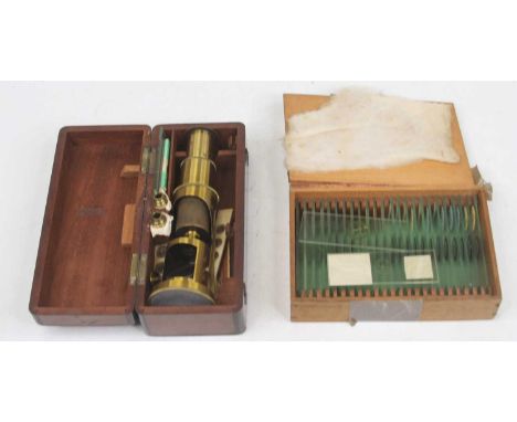 A vintage brass student's monocular mircoscope, cased; together with a collection of microscope slides (2)