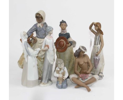 A Lladro porcelain figure of a lady holding a lamb, h.27cm; together with five Nao figures and one other Spanish porcelain fi