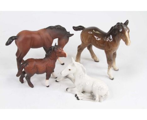 A Royal Doulton chestnut bisque model of a pony, h.11cm; together with another; and two Beswick models of ponies 