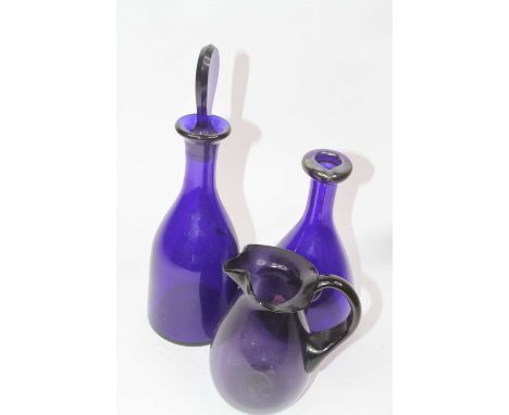 A blue glass decanter and stopper, of mallet shape, h.34cm; together with a purple art glass jug; and a blue pressed glass de