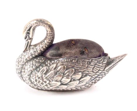 A silver figural pin cushion in the form of a swan, its bill lowered to it's neck, Birmingham 1907 by Adie and Lovekin Ltd., 