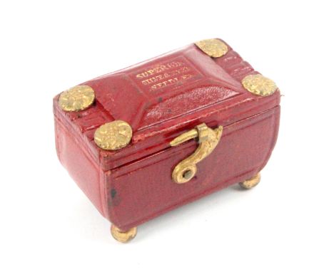 A red leather needle packet box of sarcophagol form, raised on brass ball feet, the front with exuberant leaf cast swivel hoo