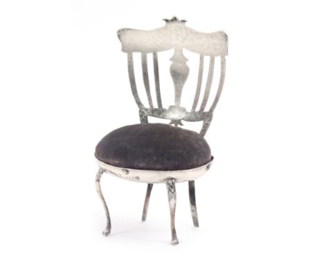 A silver pin cushion in the form of a chair, velvet seat, on cabriole legs and paw feet to the front, the back with vase spla