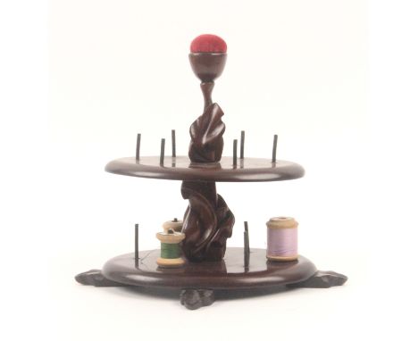 A mahogany reel stand, of two oval tiers raised on carved feet, each tier with six reel spikes with central leaf carved stem 