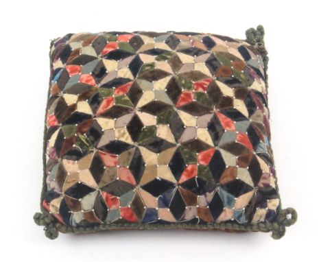 A large patchwork pin cushion, with pin stuck decoration, 19cms sq. From a distinguished UK Private Collection
