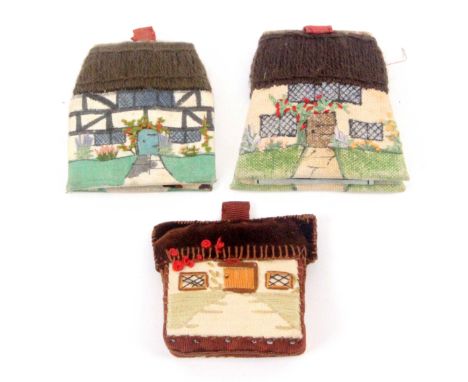 An early 20th Century embroidered cottage pin cushion and two similar needle books, the pin cushion, 5.5cms, the needle books