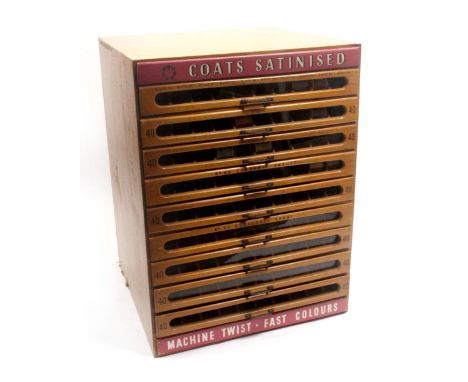 A 'Coats Satinised' beech and stained wood nine drawer counter display chest, with two raised white on mauve tablets 'Coats S