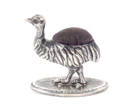 A small silver figural pin cushion in the form of a standing ostrich on oval base, Birmingham 1909 by Adie and Lovekin Ltd., 