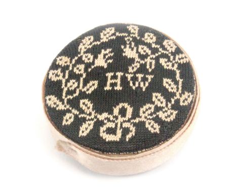 A late 18th/early 19th Century sampler style knitted pin cushion, of circular form, one side initialled in cream on green 'HW