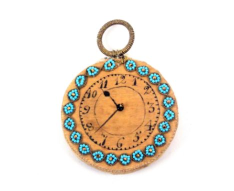 An unusual pin cushion in the form of a pocket watch, inked dial and hands within bead work floral border, the obverse with g
