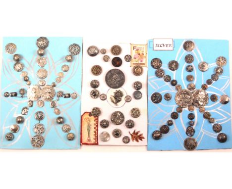 Three displays of silver and white metal buttons, comprising a display of thirty seven mostly silver, centred by a silver buc