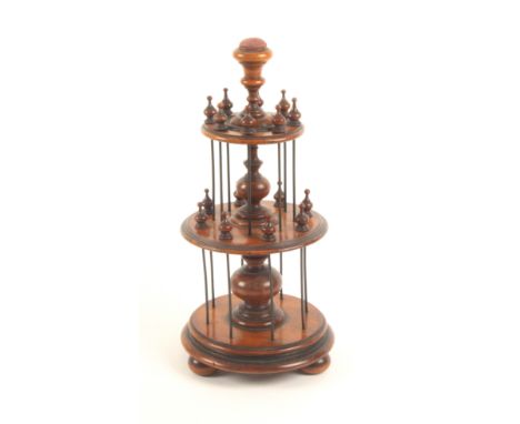 An elaborate and elegant mahogany reel stand, the circular base on three bun feet below two circular tiers divided by baluste