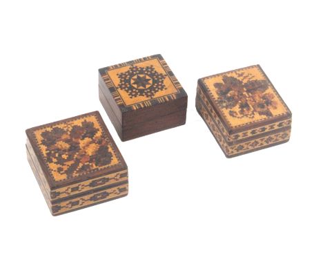 Three Tunbridge ware stamp boxes, comprising a rosewood example of square form, the lid in stick ware, 3.5cms sq. x 2cms, and