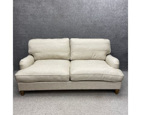 A contemporary two seater Howard style sofa bed upholstered in an oat calico raised on turned supports. Sofa L.219, mattress 