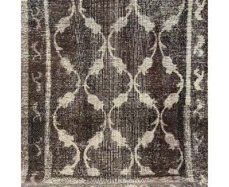 An Iranian Baluch woollen carpet with allover scrolling patterns over a mushroom ground with a complementary border. L.208 W.