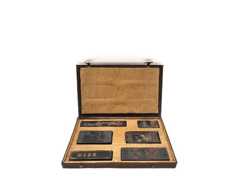 A Chinese calligraphy stone ink block set circa 1900, intricately carved in relief and hand painted with gilt embellishments,