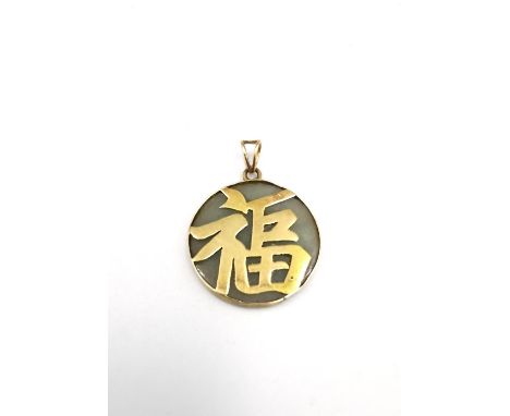 A 14k gold and jade Chinese luck character pendant with marks. 5.47g gross