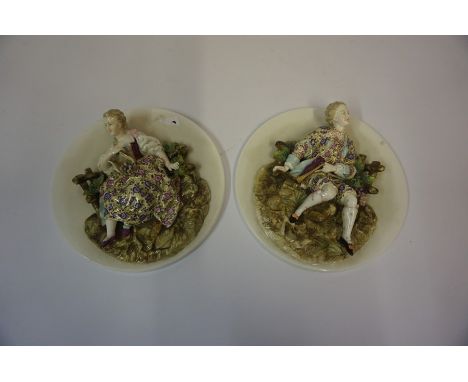Pair of Continental Porcelain Figural Wall Plaques, circa early 20th century, Modelled as a male and female, Having enamel de