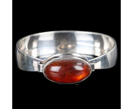 NIELS ERIK FROM - a Danish modernist sterling silver amber torque bangle, set with oval cabochon amber, setting height 18.4mm