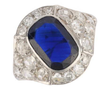 A platinum sapphire and diamond cluster ring, rub-over set with 2.8ct oval cushion-cut sapphire surrounded by old-cut diamond