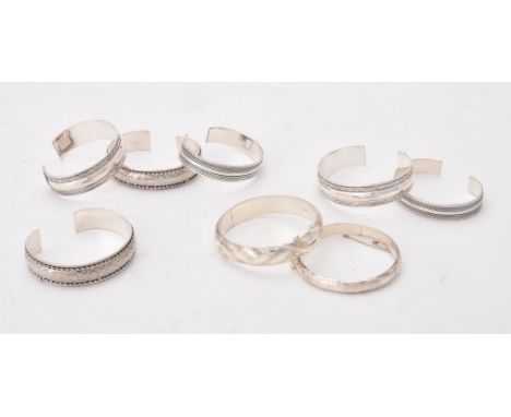 
	
		A collection of silver and silver coloured bangles, of various designs, stamped with London marks or 925, approximately 