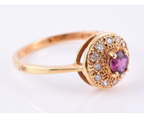 
	
		A ruby and diamond cluster ring, the central circular cut ruby within a surround of pave set brilliant cut diamonds, mou
