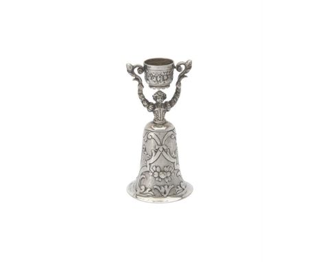 
	
		A Continental silver coloured wager cup, stamped with French import mark, modelled as a lady in a wide skirt holding alo