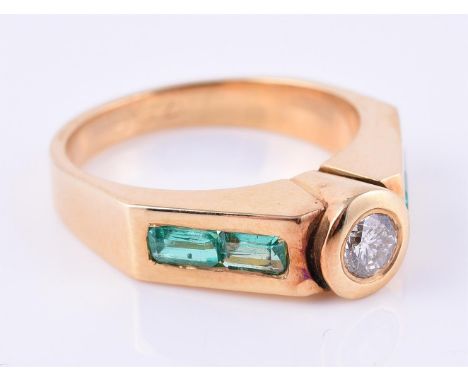 
	
		An 18 carat gold, diamond and emerald band ring, the central brilliant cut diamond, approximately 0.20 carats, rub over 